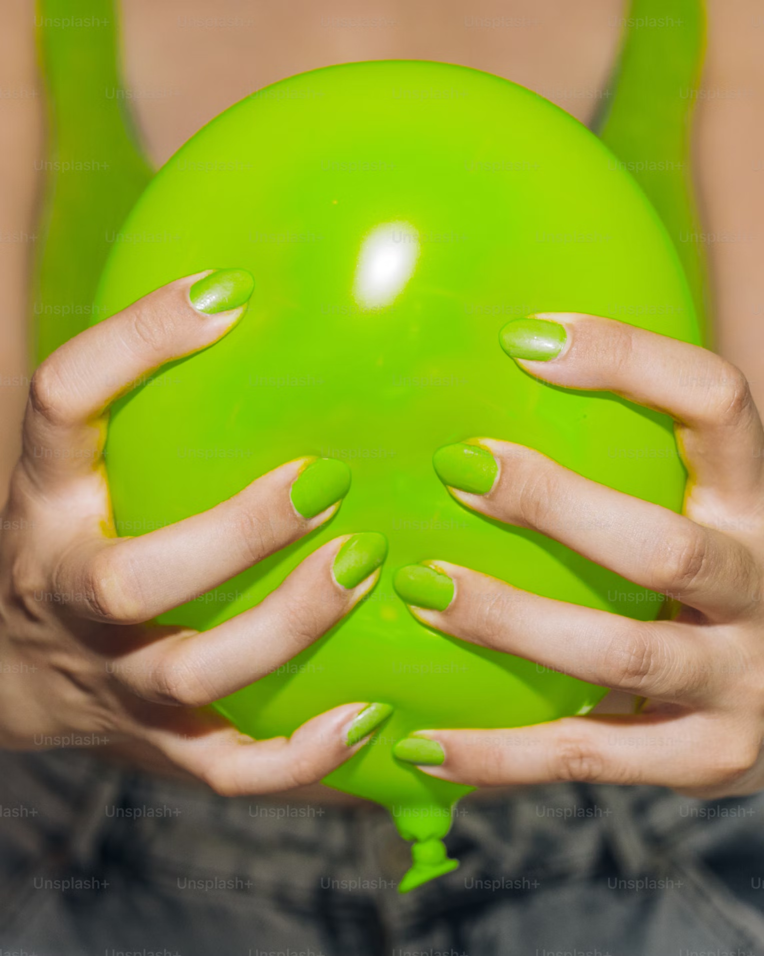 Mujer sosteniendo un globo verde.