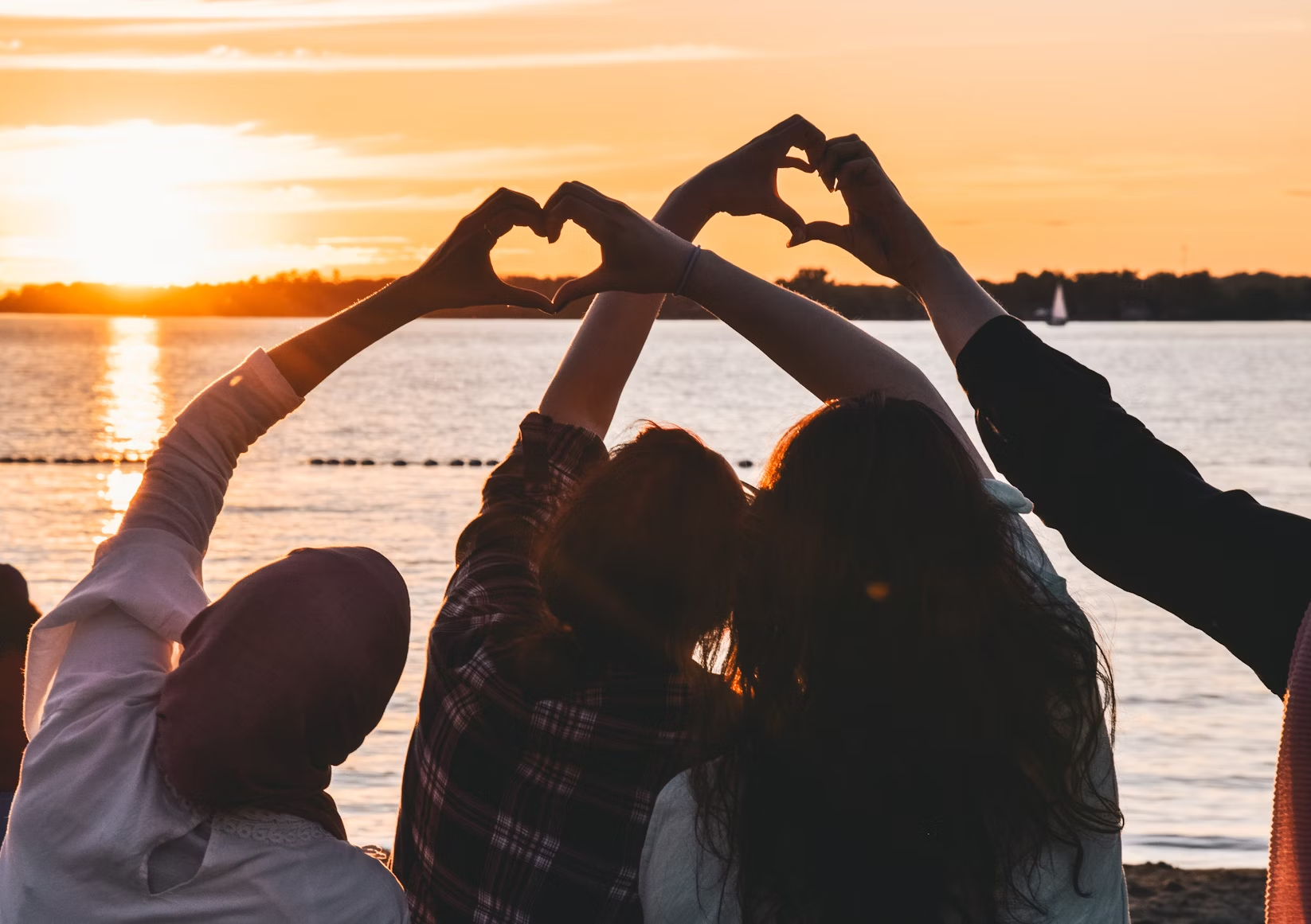 Personas formando corazones con sus manos.